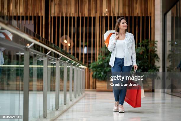 felice shopping donna che tiene borse al centro commerciale - centro commerciale foto e immagini stock