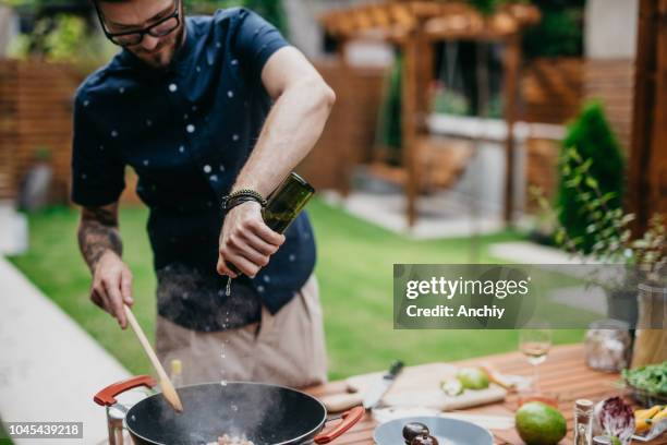 chef putting wine in a dish - outdoor kitchen stock pictures, royalty-free photos & images