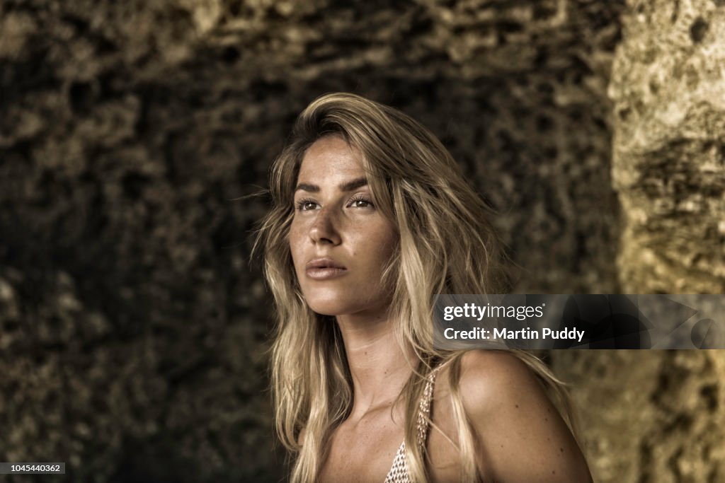 Portrait of young woman inside a cave on the beach