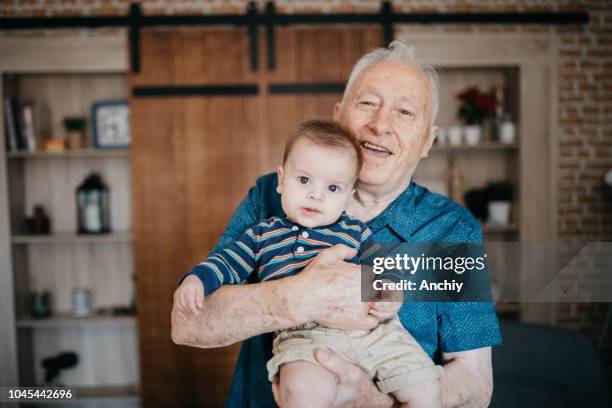 proud grandfather holding his grandson - active baby boomer stock pictures, royalty-free photos & images