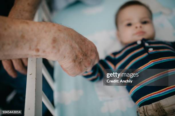 close up of grandfather and grandson holding hands top view - active baby boomer stock pictures, royalty-free photos & images