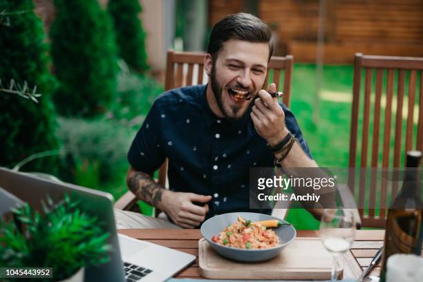 man having lunch in a garden on a sunny summer day - risotto stock pictures, royalty-free photos & images