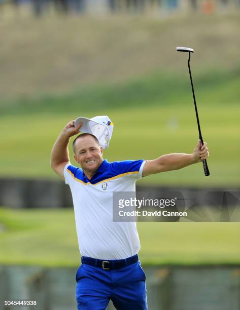 Alex Noren of Sweden and the European Team celebrates after holing a putt on the 18th green to win his match against Bryson de Chambeau of the United...