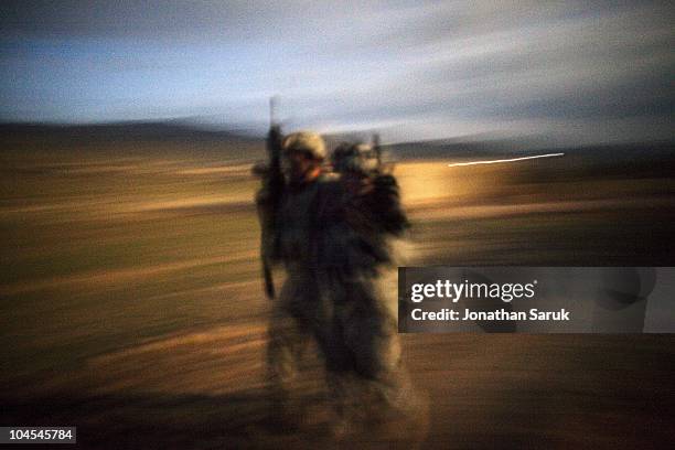 Soldier of 3rd Platoon, Delta Company of the 3rd Brigade, 10th Mountain Division helps an injured comrade at night after an ambush May 8, 2009 in the...