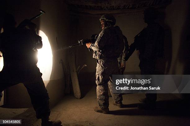 Soldiers of 3rd Platoon, Delta Company of the 3rd Brigade, 10th Mountain Division search a compound after an ambush May 8, 2009 in the Onkai Valley,...