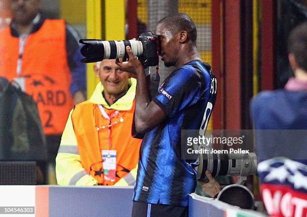 Samuel Eto'o of Milano uses a journalists camera after scoring his team's fourth goal during the UEFA Champions League group A match between FC...
