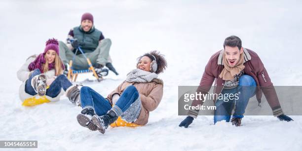 schlittenfahren spaß - winter friends playing stock-fotos und bilder