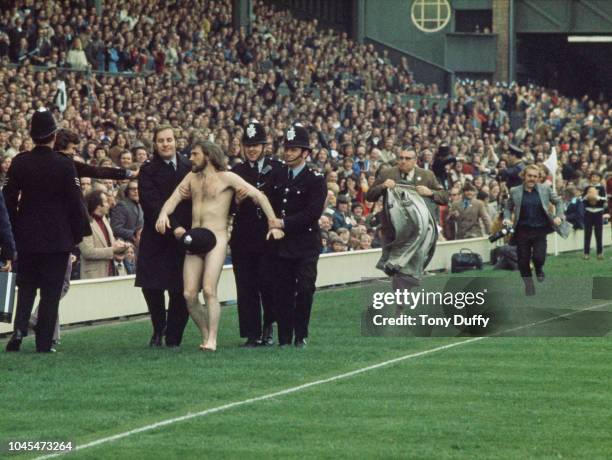 Police Constable Michael O’Brien uses his helmet to cover up streaker Bruce Perry as he is arrested and led away during the Five Nations Championship...