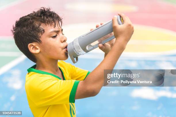 boy drinking water on court - boy drinking water stock pictures, royalty-free photos & images