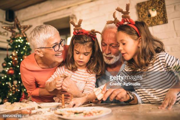 abuelos comiendo galletas con nietas - christmas cake fotografías e imágenes de stock