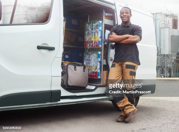 tradesman smiling next to his van infront of factory - tradesman toolkit stock pictures, royalty-free photos & images