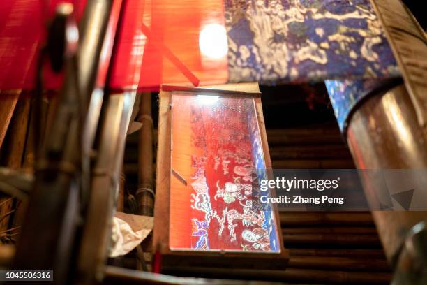 Traditional pattern of a Shu brocade, uncompleted on the wooden loom. Shu brocade, specifically refers to the silk weaving jacquard brocade produced...