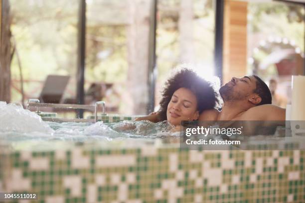 paar ontspannen in een jacuzzi in spa - bubbelbad stockfoto's en -beelden