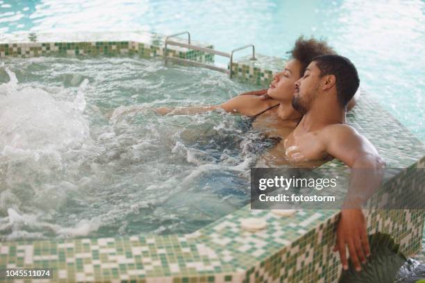 couple relaxing in a hot tub at spa - african ethnicity spa stock pictures, royalty-free photos & images