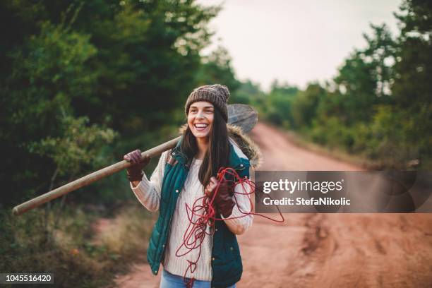 junge frau auf der suche nach einem weihnachtsbaum im wald - tree farm stock-fotos und bilder