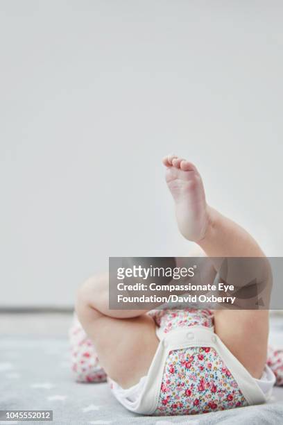 baby girl lying down with legs up - barefoot feet up lying down girl stock-fotos und bilder