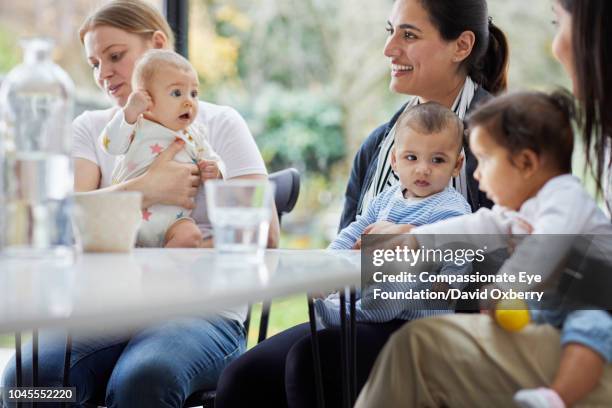 mothers and babies in kitchen - play date photos et images de collection