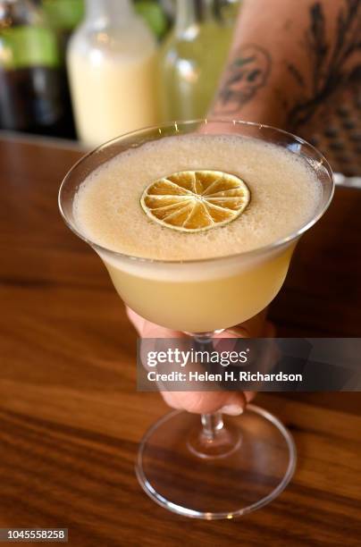 McLain Hedges, Morin's beverage director, serves a house daiquiri from behind the bar Morin on October 3, 2018 in Denver, Colorado. The daiquiri is...