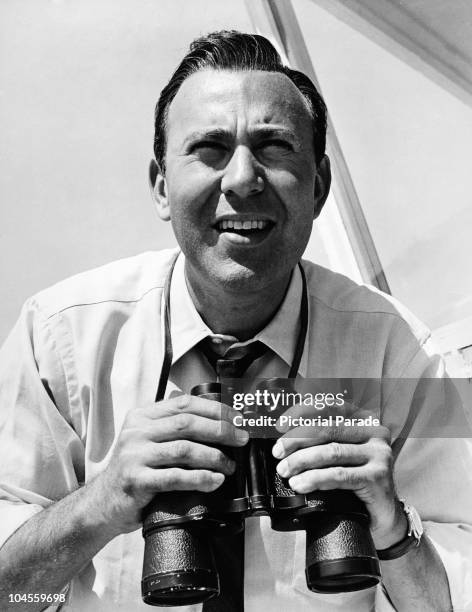 Portrait of American actor, film director and producer holding binoculars, circa 1955.