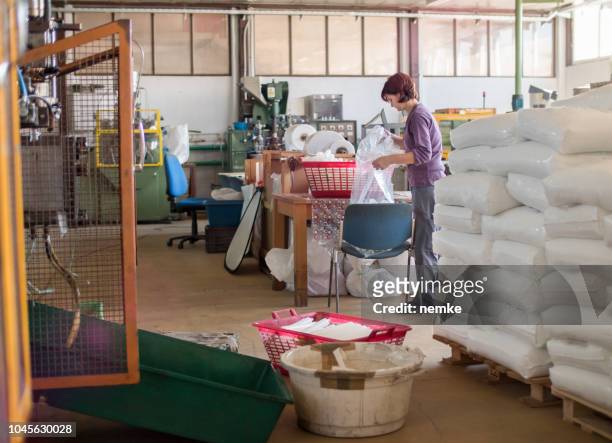 an operator loads part onto a pallet at a manual station - labor intensive production line stock pictures, royalty-free photos & images