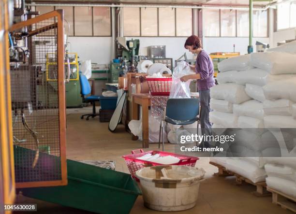 an operator loads part onto a pallet at a manual station - labor intensive production line imagens e fotografias de stock