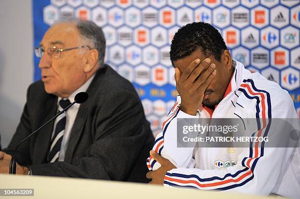 France's captain Patrice Evra reacts next to Jean-Pierre Escalettes , president of the French Football Federation, during a press conference in...