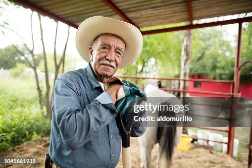 Felice uomo messicano anziano che lavora al ranch di cavalli Felice uomo messicano anziano che lavora al ranch di cavalli