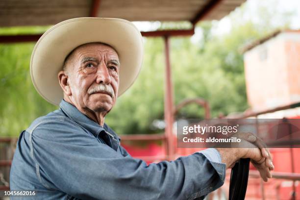 senior mexikanische mann trägt hut und wegsehen - mexikanischer abstammung stock-fotos und bilder