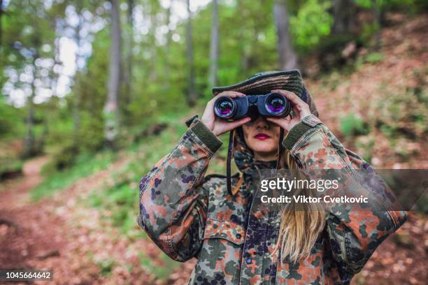camouflage woman scout in forest - spy hunter stock pictures, royalty-free photos & images