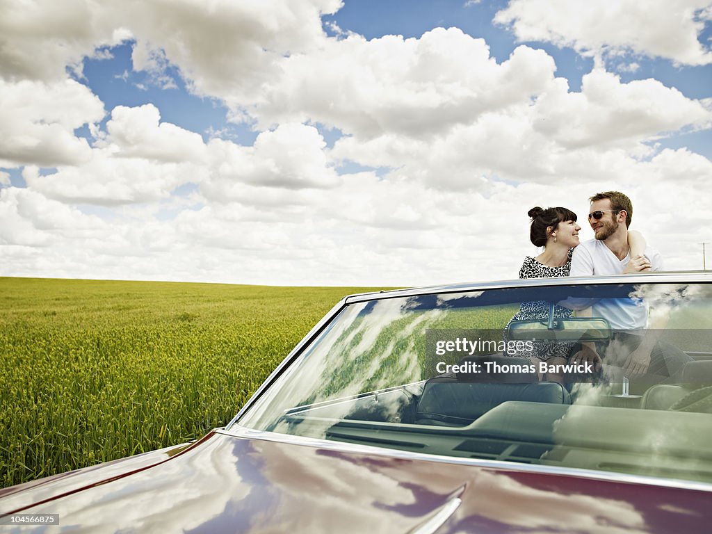 Young couple sitting on backseat of convertible