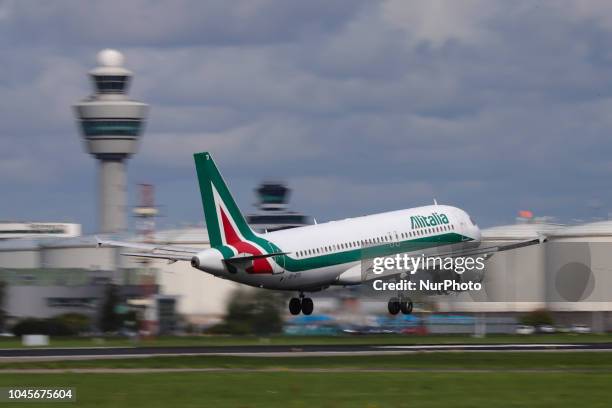 Alitalia Airbus A320-200 with registration EI-DTI is landing at Amsterdam Schiphol International Airport during a sunny day. The airplane is named...