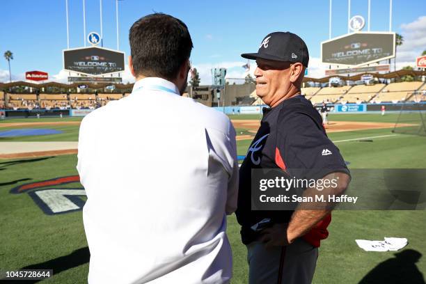 General manager Alex Anthopoulos and manager Brian Snitker of the Atlanta Braves talk during batting practice prior to Game One of the National...