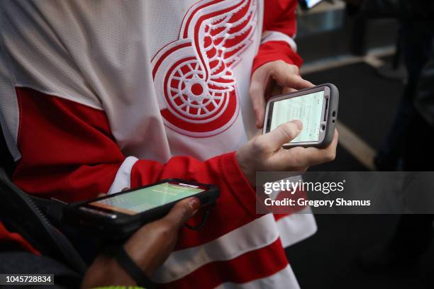 Fans have their tickets scanned on their phone while entering a game between the Columbus Blue Jackets and Detroit Red Wings at Little Caesars Arena...