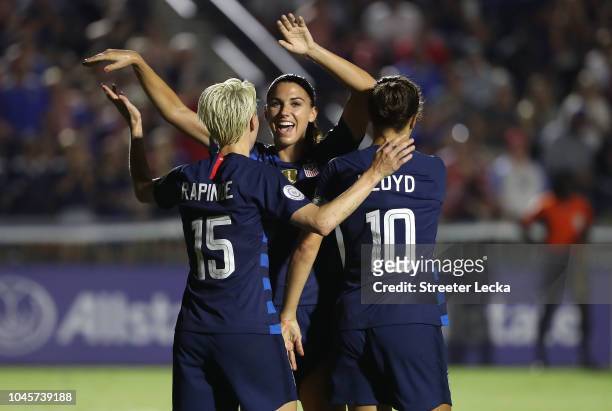 Megan Rapinoe reacts after scoring a goal as she celebrates with teammates Alex Morgan and Carli Lloyd of USA against Mexico during the Group A -...
