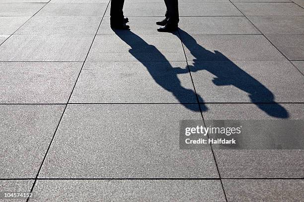 the shadow of two businessmen shaking hands, focus on shadow - 2 businessmen in silhouette stock pictures, royalty-free photos & images