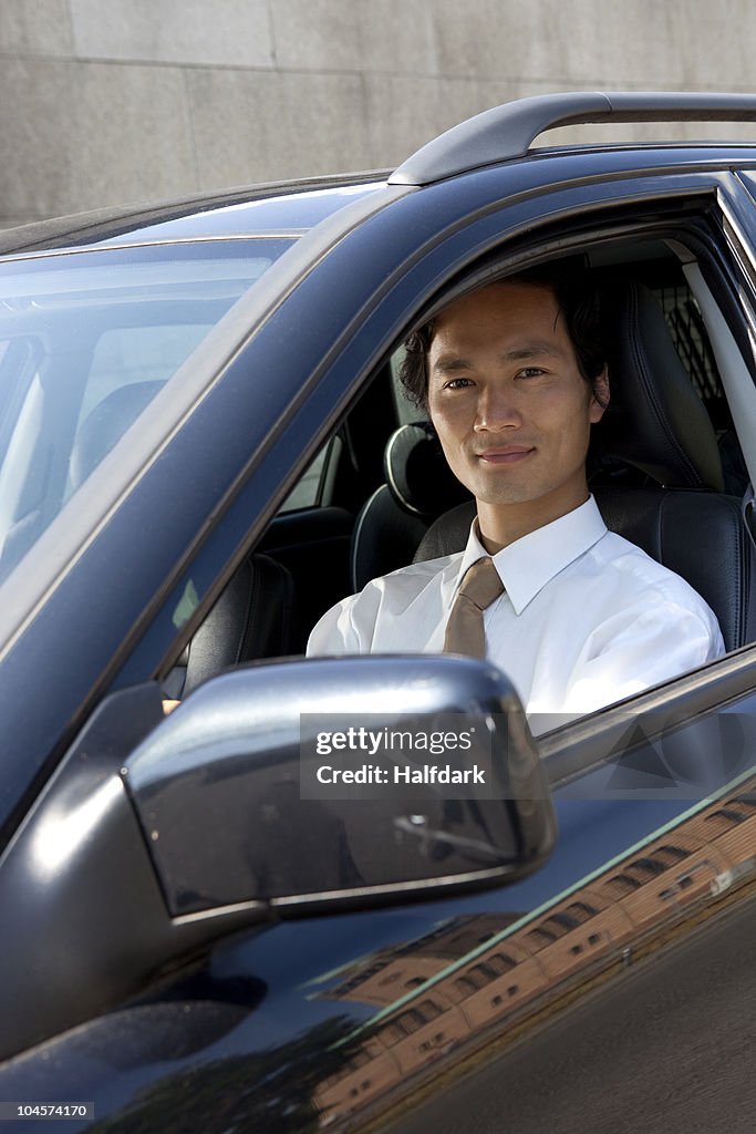 A businessman in his car, looking at camera