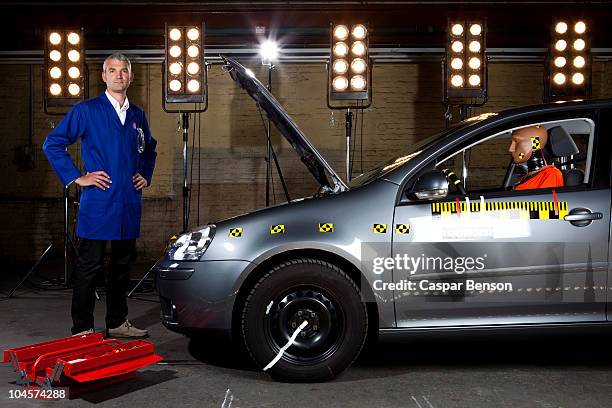 a technician standing next to a crash test car - crash test stock-fotos und bilder