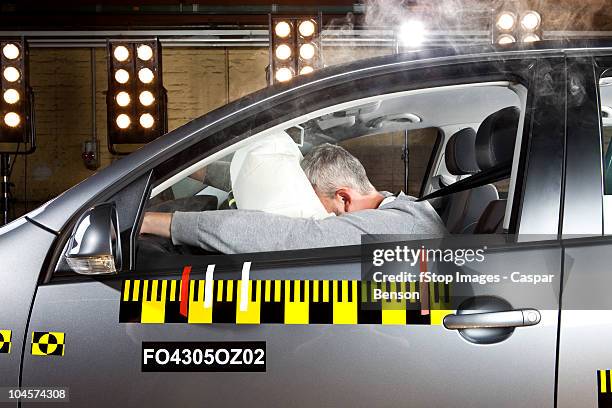 a man's face impacting an airbag in a crash test car - airbag stockfoto's en -beelden