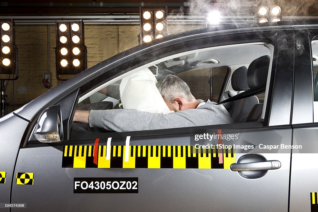 A man's face impacting an airbag in a crash test car