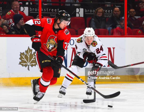 Thomas Chabot of the Ottawa Senators stickhandles the puck with Dominik Kahun of the Chicago Blackhawks chasing at Canadian Tire Centre on October 4,...