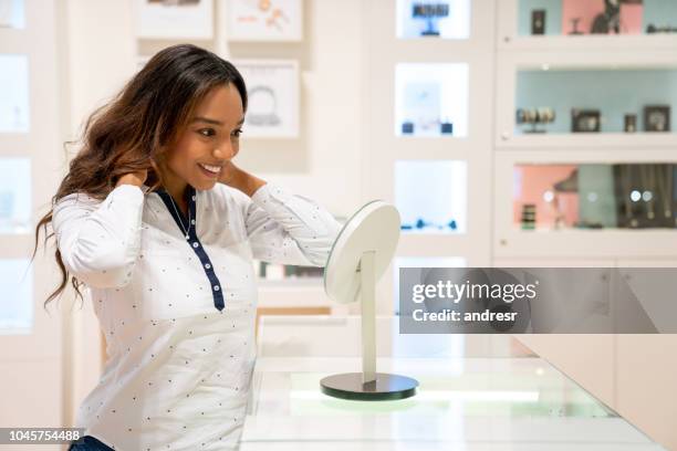 beautiful woman buying jewels at a jewelry store - jewellery shopping stock pictures, royalty-free photos & images