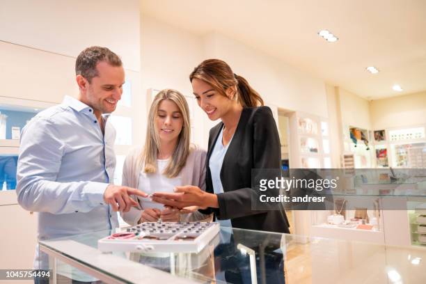 happy couple shopping at the jewelry store - jewelry store stock pictures, royalty-free photos & images