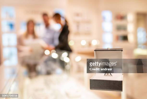 couple buying an engagement ring at a jewelry store - jeweller stock pictures, royalty-free photos & images