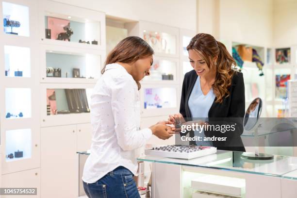 happy woman buying jewels at a jewelry store - jewellery shop stock pictures, royalty-free photos & images