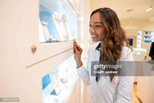 happy woman looking at jewels at a jewelry store - jewellery shopping stock pictures, royalty-free photos & images