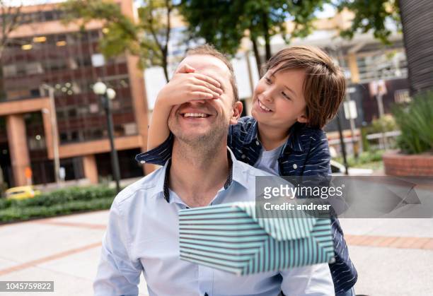 boy surprising his father with a gift for father's day - father gift stock pictures, royalty-free photos & images