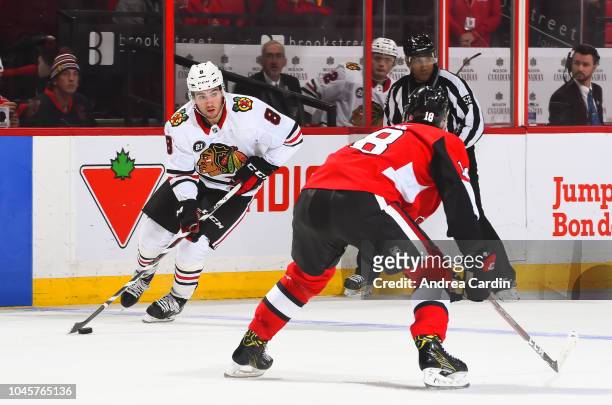 Nick Schmaltz of the Chicago Blackhawks stickhandles the puck with pressure from Ryan Dzingel of the Ottawa Senators at Canadian Tire Centre on...