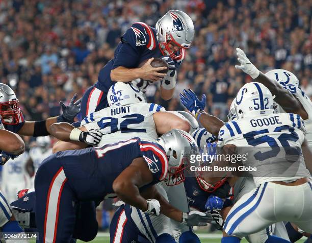 New England Patriots quarterback Tom Brady goes over the top of Colts defenders as he scores a second quarter touchdown. The New England Patriots...