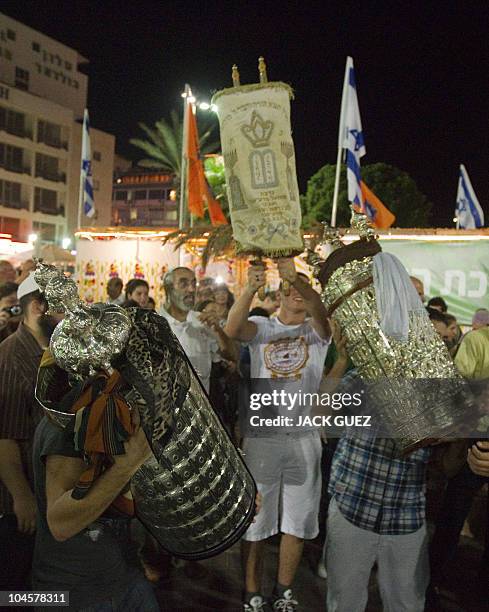 Jews dance with the Torah scrolls during the Simhat Torah celebration in the coastal city of Netanya, north of Tel Aviv on September 30, 2010. Simhat...
