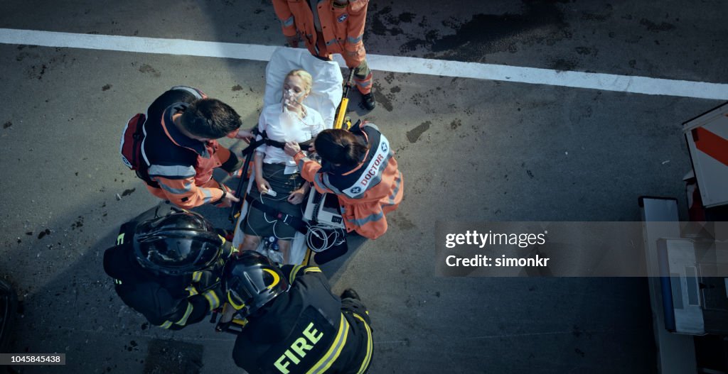 Sanitäter Team stabilisieren verletzte Frau auf Bahre am Unfallort